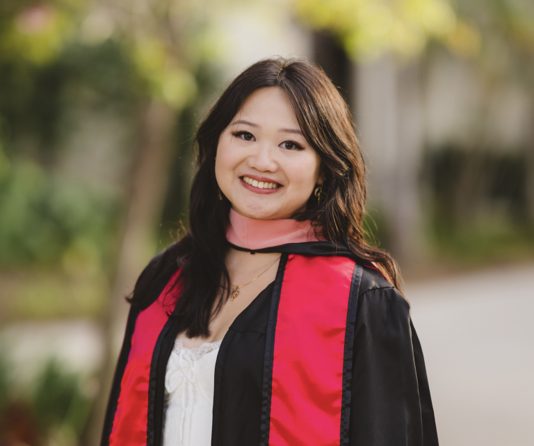headshot of Fellow Dana Angeles in her graduation robe with a red masters ribbon